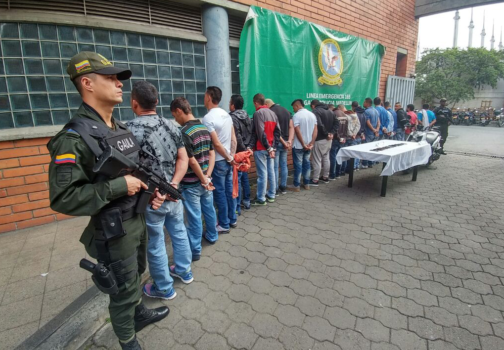 Dos policías del GAULA custodian a 18 personas filadas con esposas