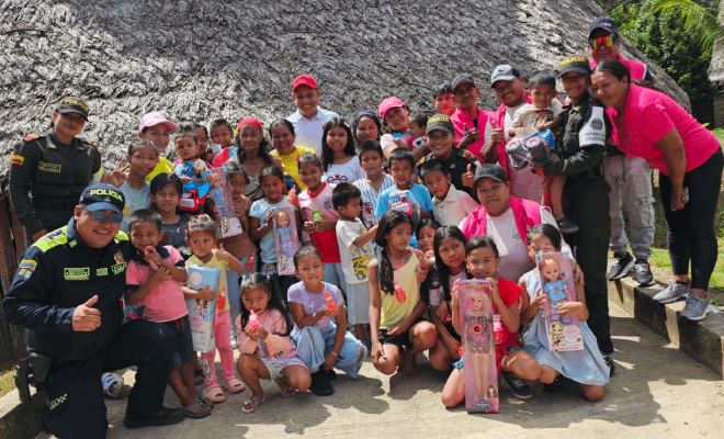 Tres polic&iacute;as y, a los lados de ellos, varios ni&ntilde;os de pie junto a funcionarios p&uacute;blicos