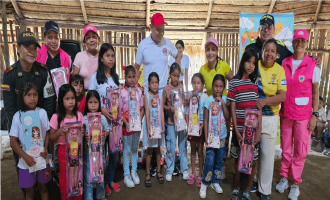 Dos policías y a los lados de ellos varios niños de pie junto a funcionarios públicos