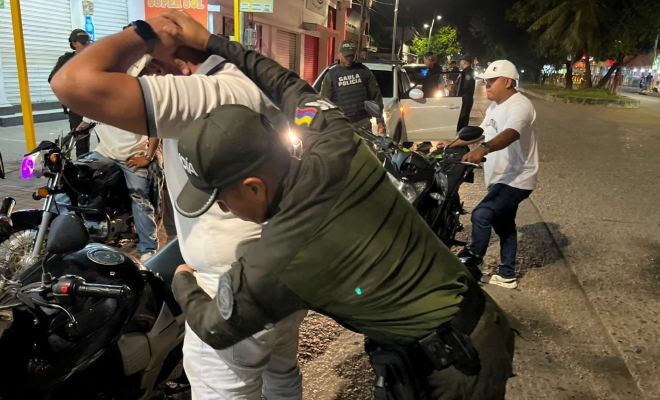 Grupo de policías del GAULA realizando actividades de registro a personas a dos ciudadanos 