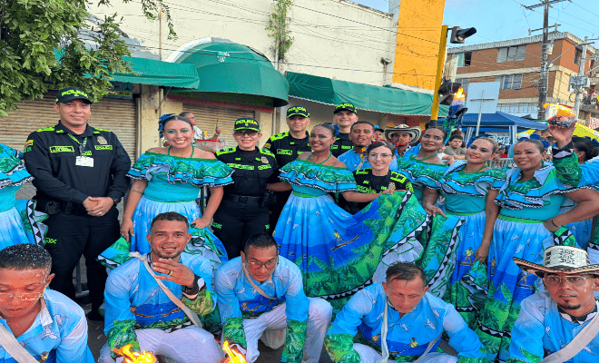 cuatro uniformados con un grupo de participantes de comparsas feria nacional de la ganadería 
