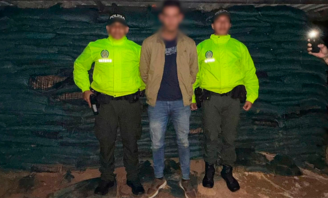 El capturado alias 'Firulais', presunto integrante del ELN, es custodiado por dos policías