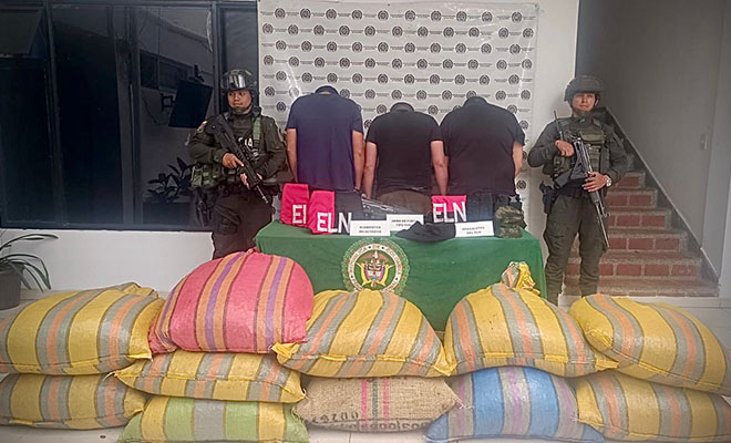 tres personas, con brazaletes alusivos al grupo armado organizado ELN y 70 bultos de cacao 