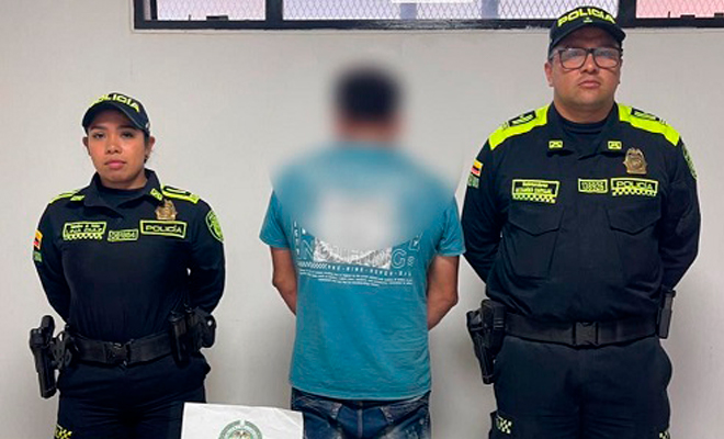 Persona capturada vestida con camiseta azul junto a dos uniformados de la Polic&iacute;a Nacional