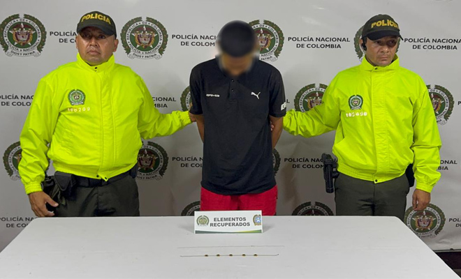 Dos polic&iacute;as de la sijin con un capturado por hurto y dos cadenas de oro sobre la mesa las cuales fueron recuperadas