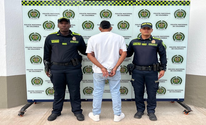 una persona de espalda capturada por delitos sexuales y dos Polic&iacute;as brindando seguridad 