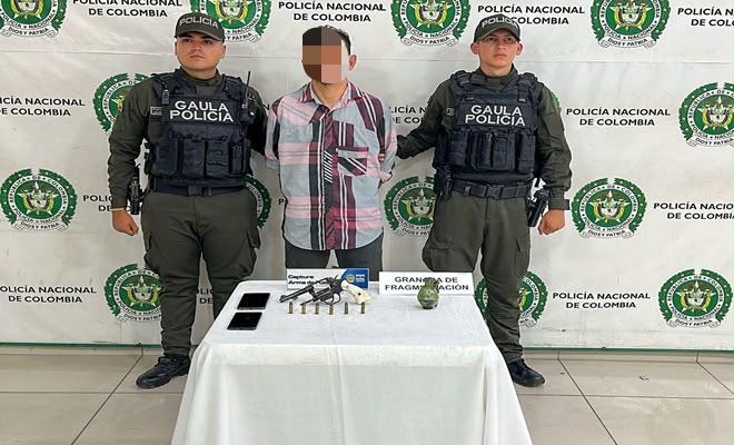 Una persona de sexo masculino capturada por el delito de fabricaci&oacute;n, tr&aacute;fico y porte de armas, municiones de uso restringido y privativo de las fuerzas armadas o explosivos, acompa&ntilde;ado de dos uniformados de la Polic&iacute;a Nacional brindando seguridad. 