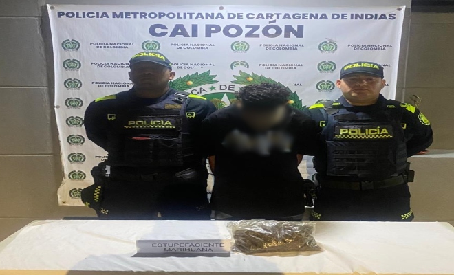 Dos policías, un capturado por el delito de trafico de estupefacientes los cuales se muestran encima de una mesa