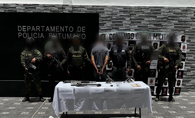 Polic&iacute;a, GAULA Militar y CTI junto a sujeto capturado y elementos incautados frente a una mesa