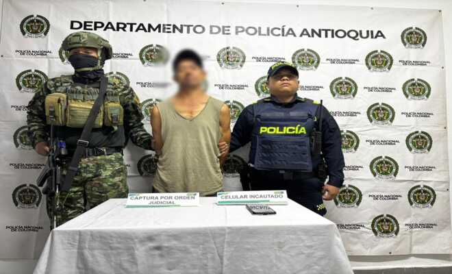 Un soldado y un policía custodian a un capturado