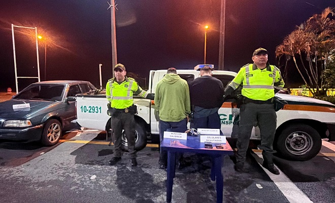 Dos polic&iacute;as con  dos personas Capturadas