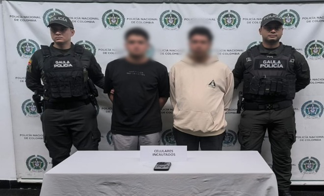 Dos polic&iacute;as del GAULA custodian a dos capturados por extorsi&oacute;n