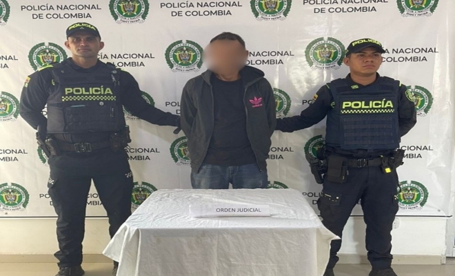 Dos policías custodian sujeto capturado