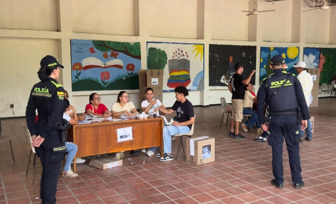 Dos uniformados de la Policía Nacional prestan servicio de seguridad durante la jornada electoral en una institución educativa habilitada como puesto de votación