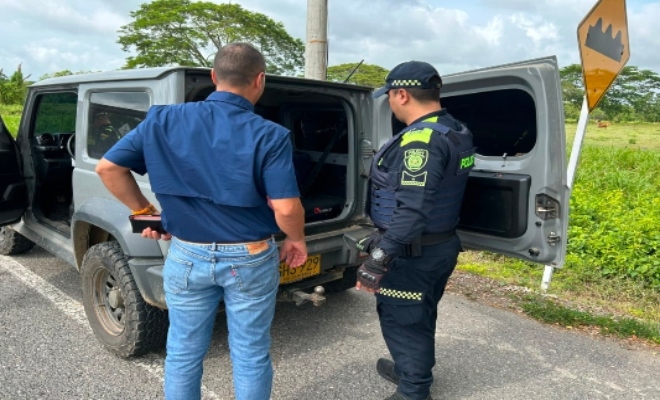 Un uniformado de la Polic&iacute;a Nacional junto a un ciudadano, durante el registro de su veh&iacute;culo en el marco de los planes de control que realiza la instituci&oacute;n