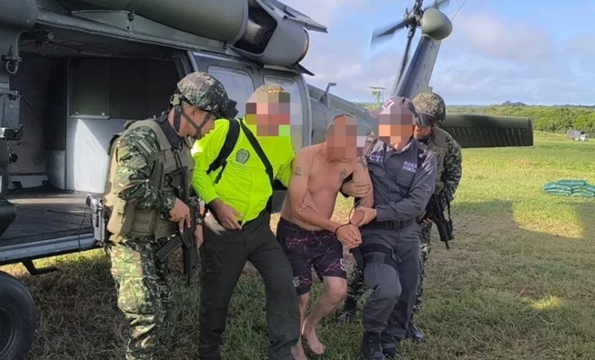 Cuatro uniformados, un capturado y un helicóptero en fondo