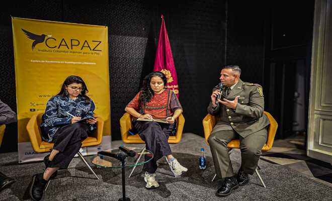 Dos mujeres un polícia en un conversatorio.
