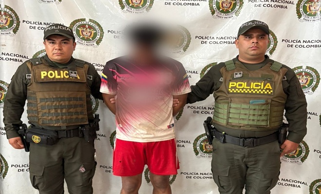 Dos policías custodiando el capturado por homicidio
