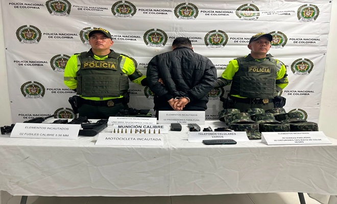 Dos polic&iacute;as de tr&aacute;nsito custodiando un capturado, armamento y prendas militares