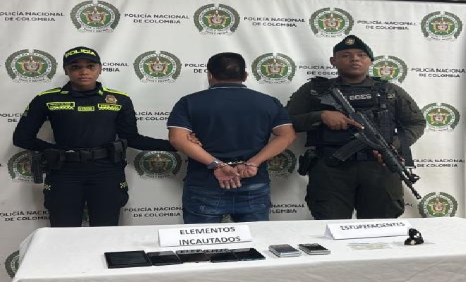 Persona capturada custodiada por uniformados de la Polic&iacute;a Nacional durante la presentaci&oacute;n de un resultado operativo contra la criminalidad en el departamento del Guain&iacute;a.