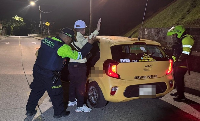 Dos policías de vigilancia realizando registro a persona y a un vehículo publico