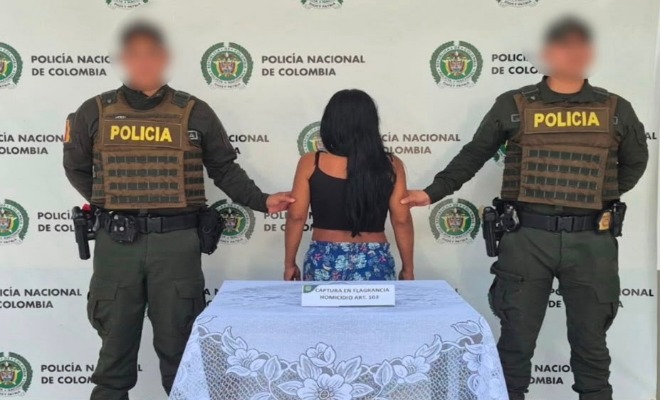 Dos polic&iacute;as agarrando de los brazos a una mujer capturada 