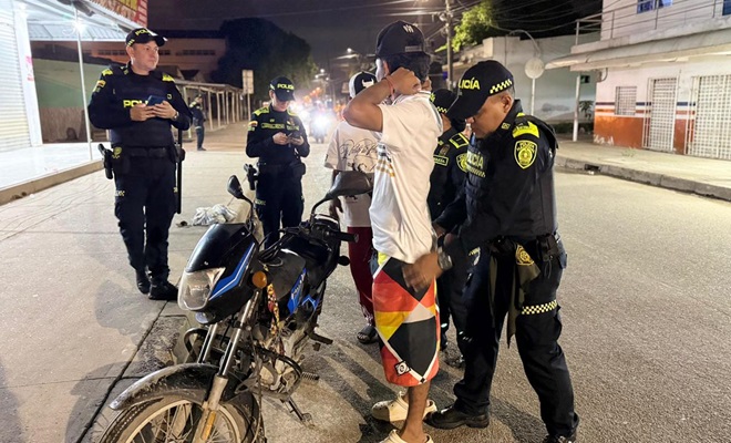 Funcionarios policiales realizando registro a dos ciudadanos y verificación de antecedentes