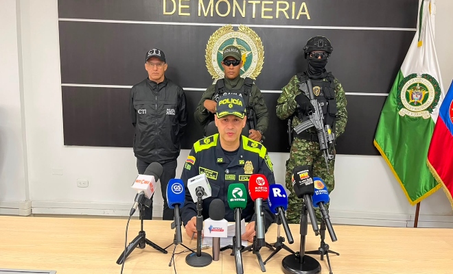 un señor oficial de la policía nacional con tres uniformados en rueda de prensa  