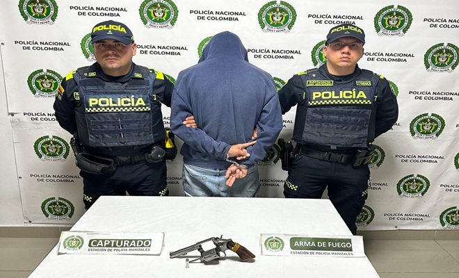 dos policías, un capturado, un arma de fuego, una mesa 