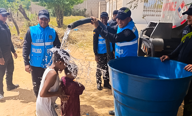 Polic&iacute;as de la Polic&iacute;a Nacional entregan agua potable a familias del barrio Brisas del Mar, en Riohacha, llevando apoyo y bienestar a la comunidad
