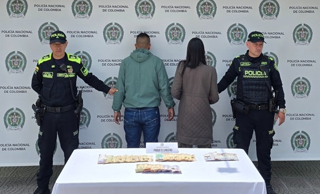 Dos policías, dos capturados de espaldas y dinero incautado al parecer falso encima de una mesa  