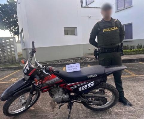 Policía junto a una motocicleta