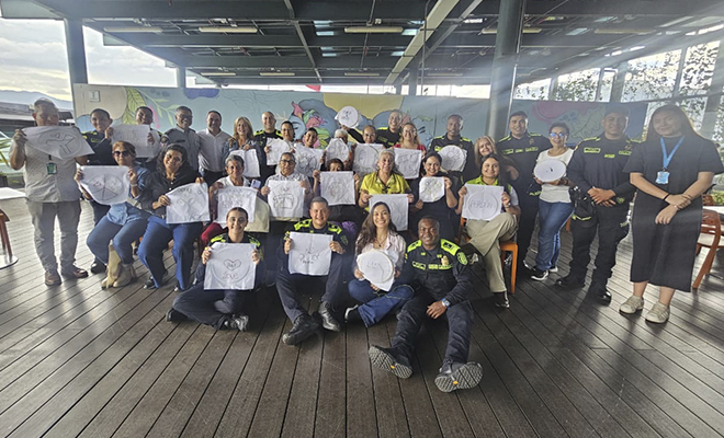 Polic&iacute;as y comunidad sonriendo para la foto con manualidades terminadas