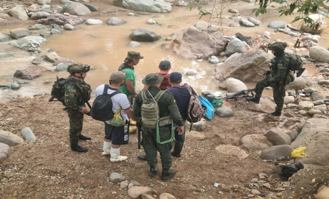 Personal de la policía y ejército en un campo abierto incautando material para minería ilegal