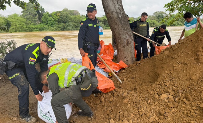 Policías cargando sacos con arena