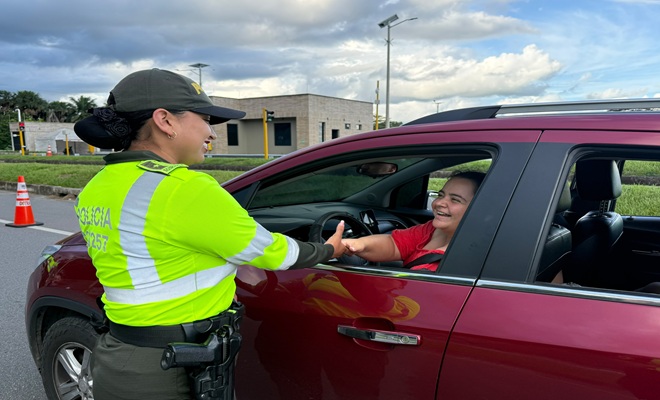 Policía de tránsito saludando una ciudadana