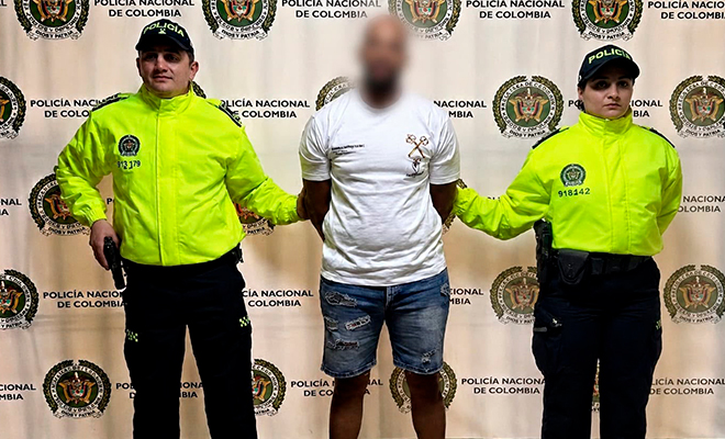 Ciudadano Neerlandés retenido en Medellín, es custodiado por dos funcionarios de la policía nacional.
