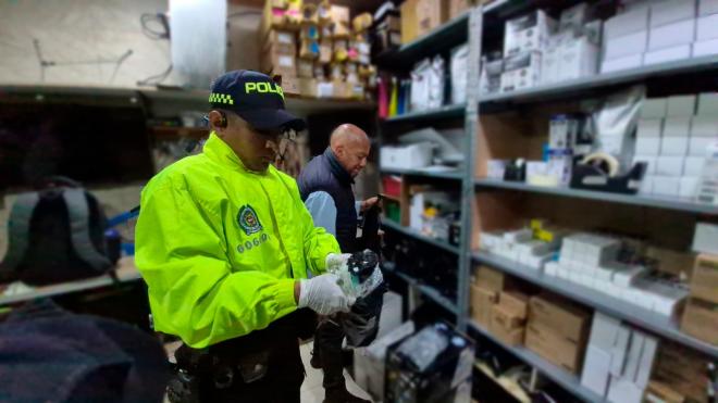 Funcionario de Policía Judicial, verificando los elementos de oficina hallados en los locales comerciales.