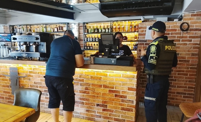 Funcionario policial en local comercial con un ciudadano