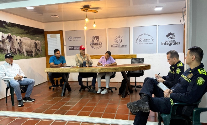 dos señores oficiales de la policía nacional en reunión con cuarto funcionarios de Ganacor 
