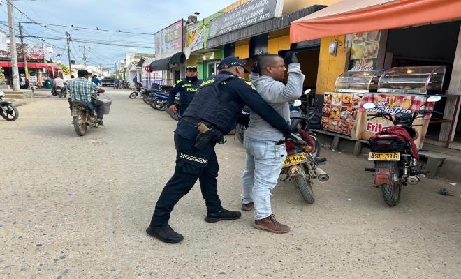 Un policía garantizando la seguridad mediante registro a un ciudadano 