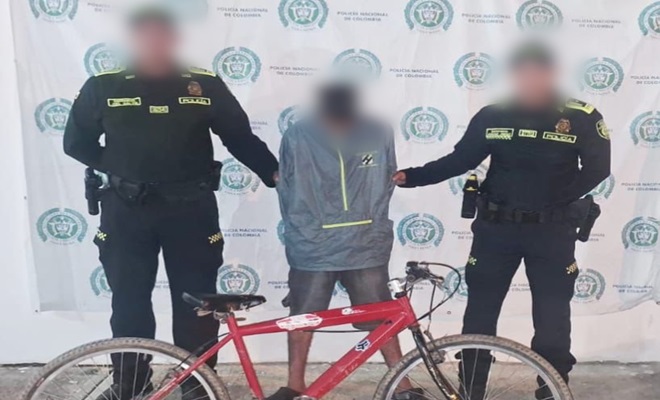 Dos policías con un capturado y una bicicleta