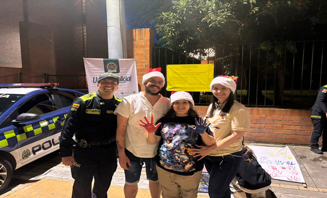 Un policía con una familia mostrando las manos pintadas