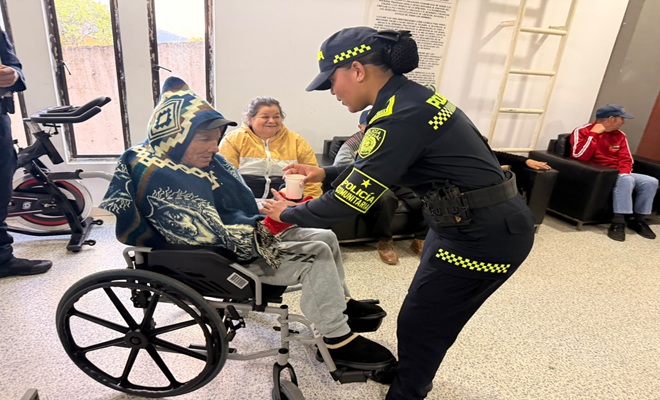 Un adulto mayor en silla de ruedas junto a una polic&iacute;a