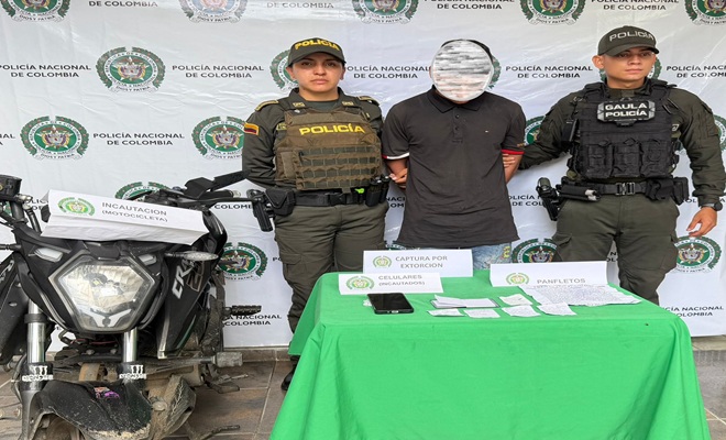 Una motocicleta y un capturado custodiado por dos polic&iacute;as