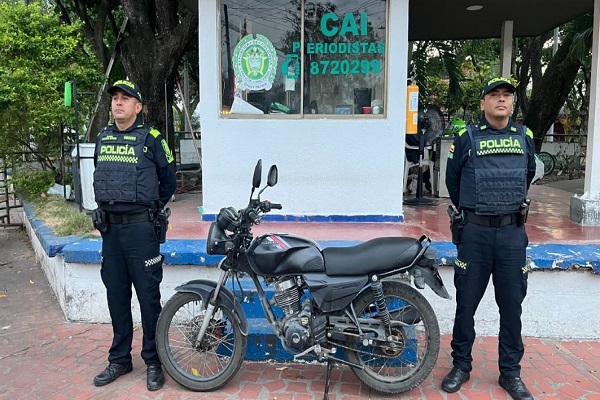 Dos policías junto a la motocicleta recuperada