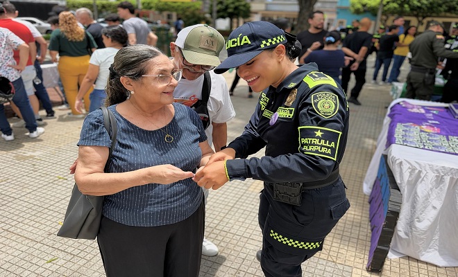 Uniformada del grupo de Patrulla Púrpura brindando campaña de sensibilización y prevención a una ciudadana  