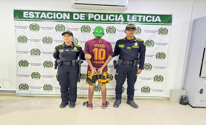 Dos policías  y una persona capturada de espaldas