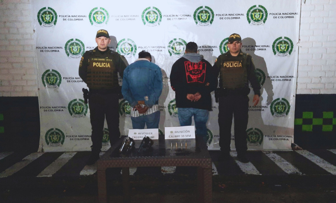 Personas capturadas-policías custodiando