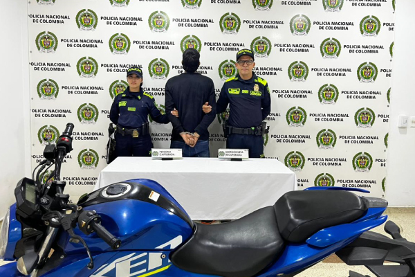 Hombre capturado en medio de dos policías, en frete motocicleta recuperada